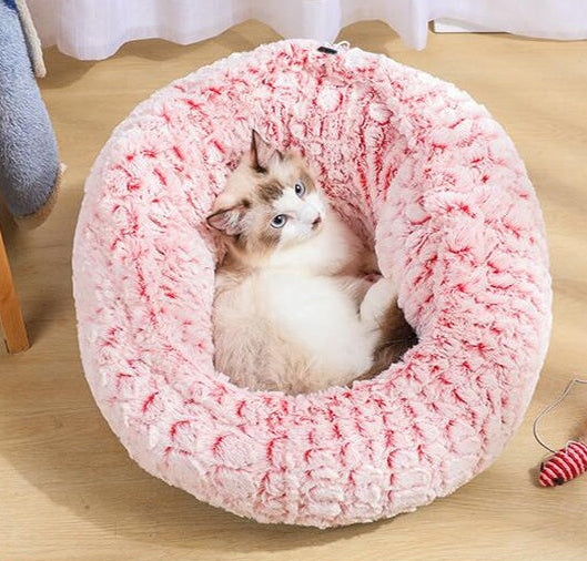 Pink plush pet bed with cat curled inside